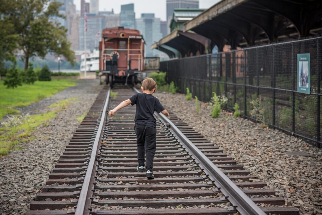 A child walking along train tracks