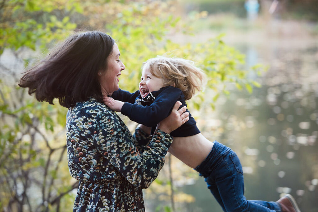 A mom swinging their child around 