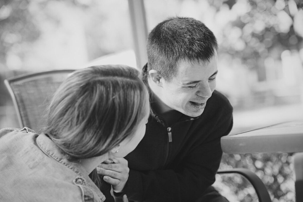 Black and white photo of two people laughing 
