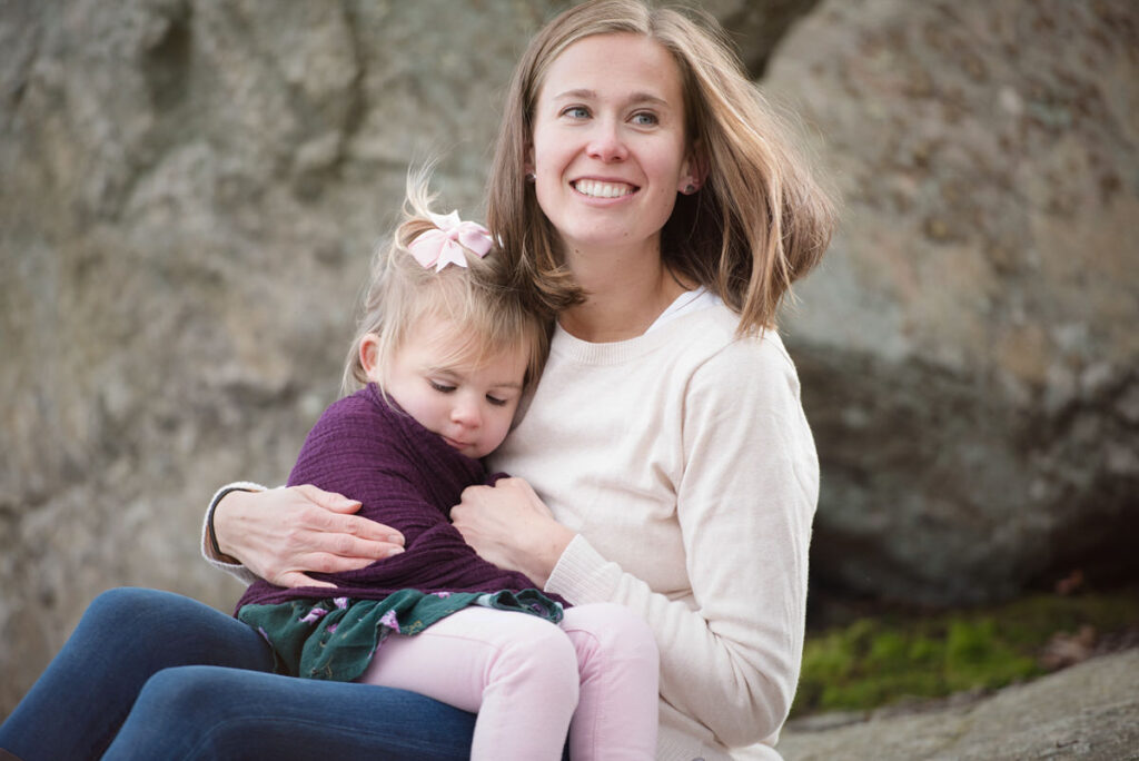 A small child sitting on their mother's lap 