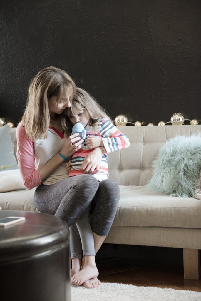 A small girl sitting on her mother's lap 