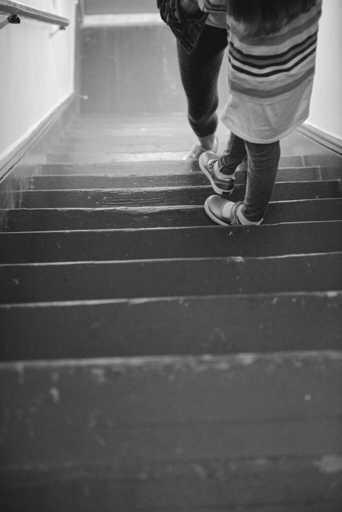 Two people walking down a staircase 
