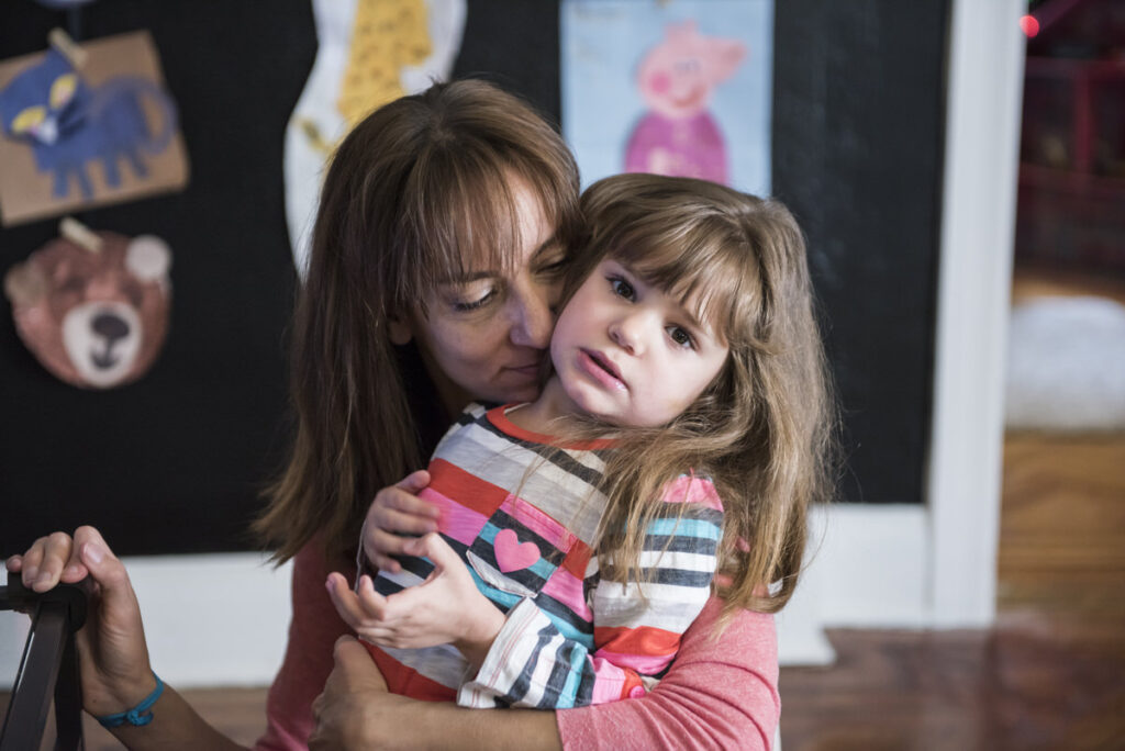 A parent wrapping their arms around their child 