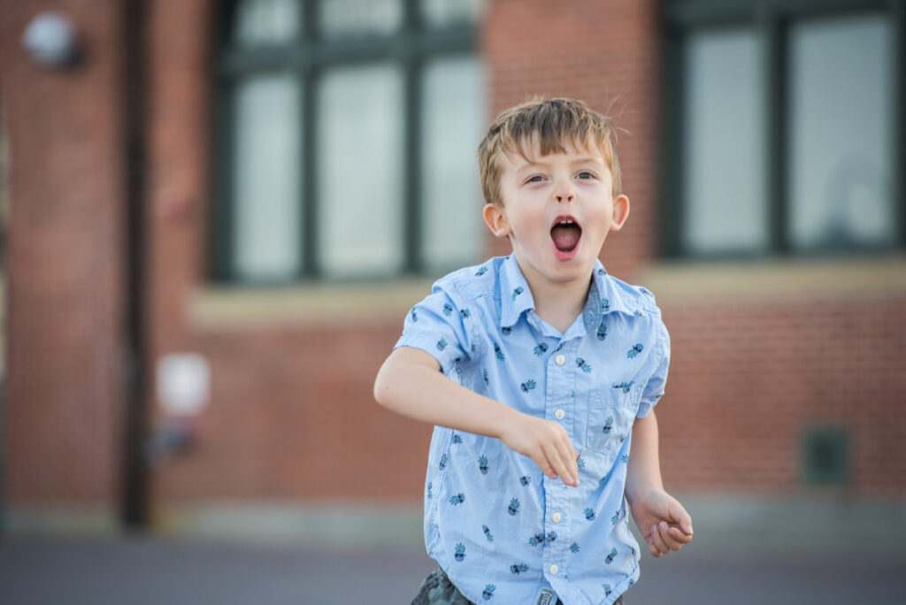 A young boy smiling and yelling 
