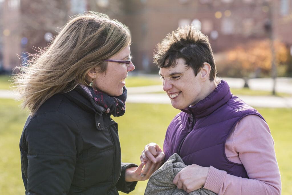 A mom and son smiling in a park 
