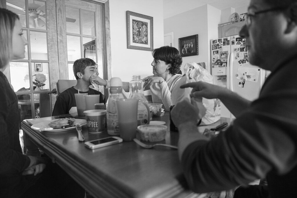 A family sitting around a dinner table 
