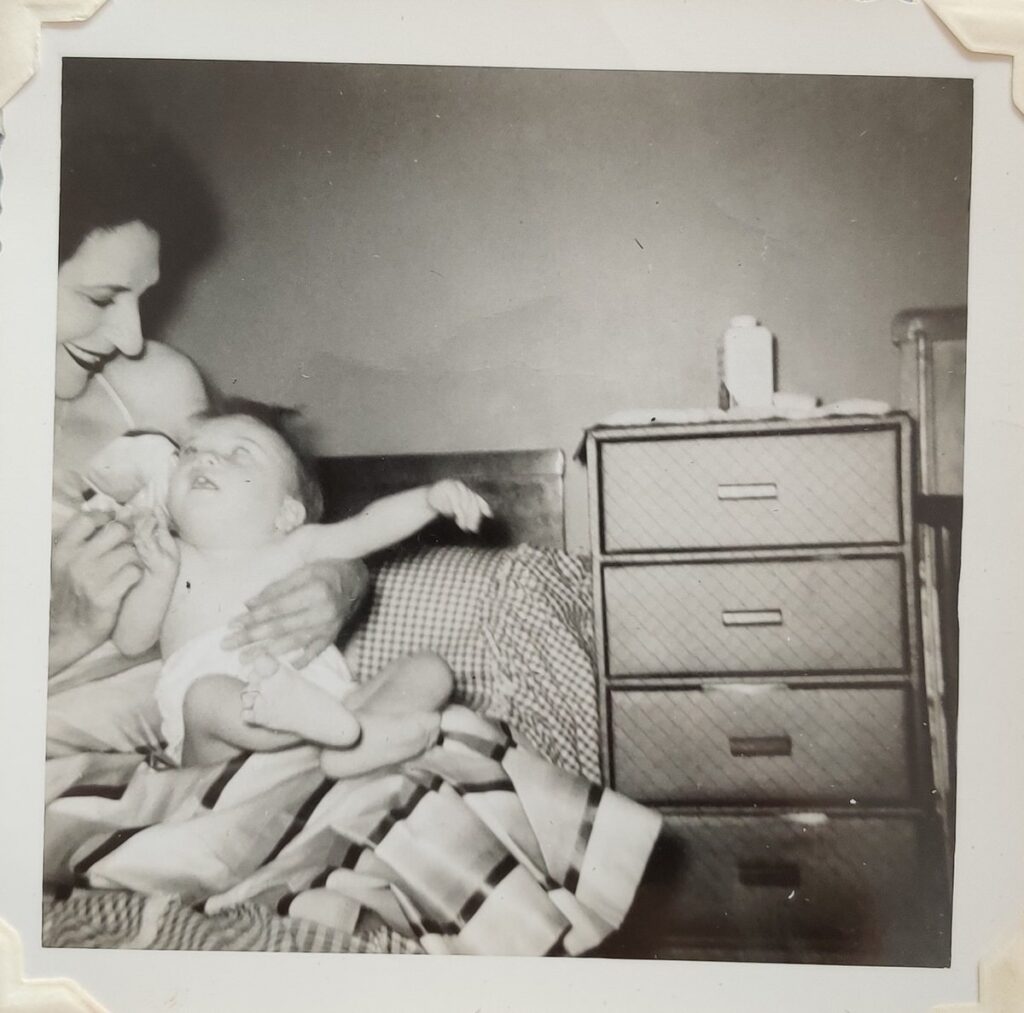 A vintage photo of a woman holding a small baby 
