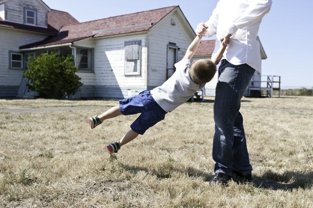 A parent swinging their child around 