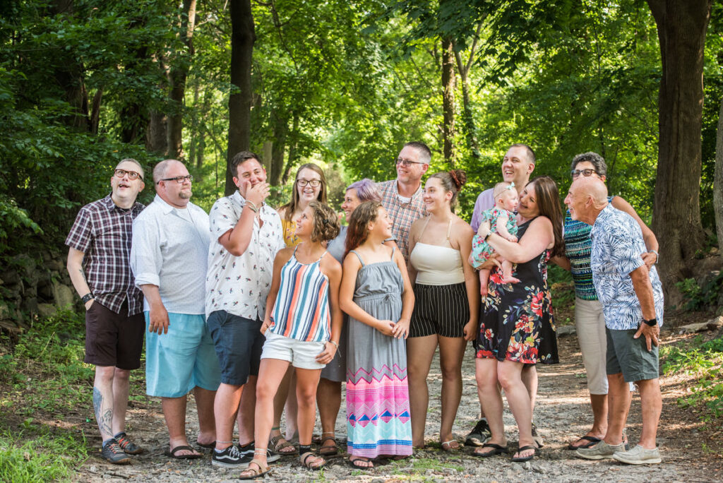 A large family laughing and standing on a trail 