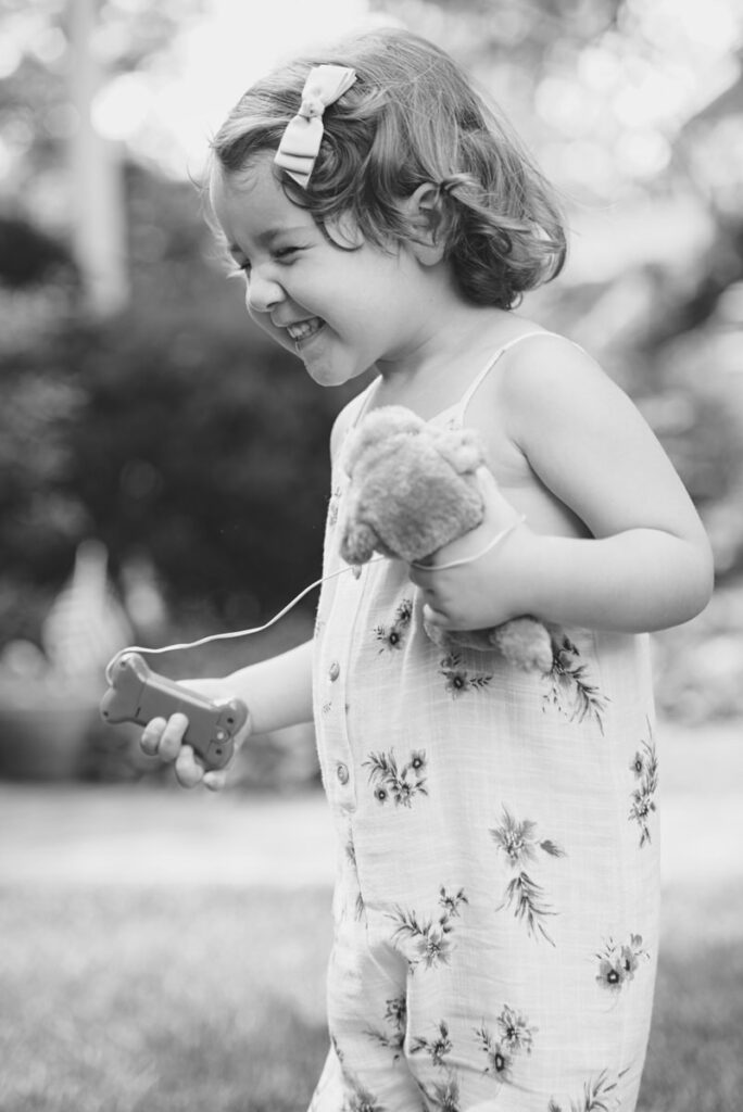 A small child smiling while holding a stuffed animal 