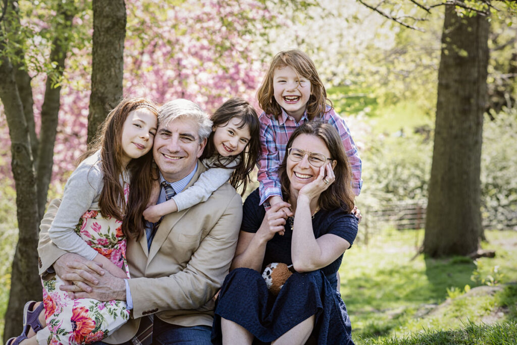 A family of five all smiling and hugging each other. 