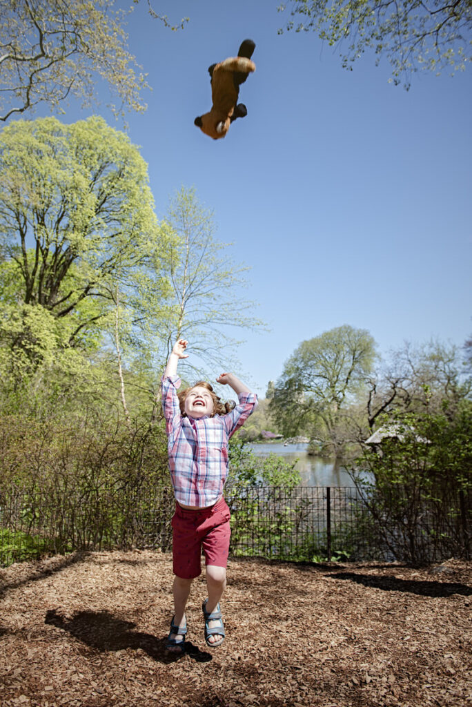 A boy throwing up a stuffed animal 