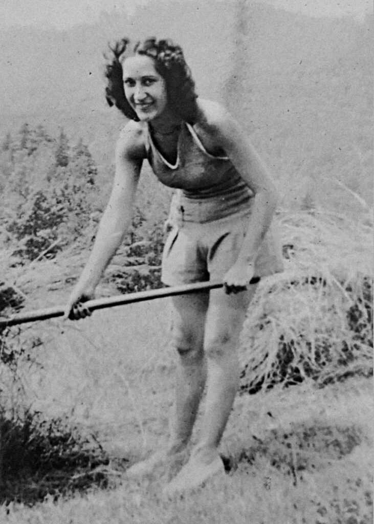 Black and white photo of a woman working in a yard 