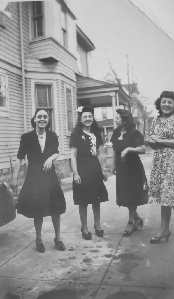 A group of women laughing and walking on a sidewalk 